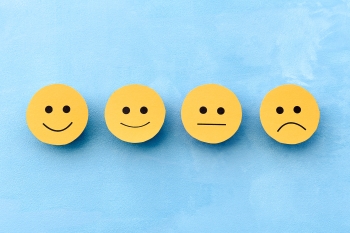 4 smiley faces with varying expressions from sad to happy image